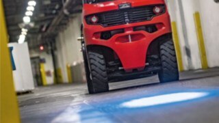 Linde-motviktstruck med BlueSpot projicerar en blå varningspunkt på hallgolvet