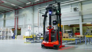 En automatiserad truck från Linde plockar pallar från bandtransportör En automatiserad truck från Linde plockar pallar från bandtransportör
