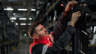 Belysnings- och varningssystem från Linde Material Handling möjliggör säker och exakt hantering. En servicetekniker från Linde monterar en belysningslösning