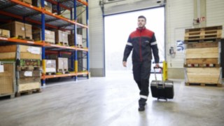 En tekniker från Linde Material Handling går genom ett lager