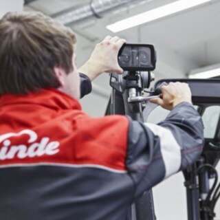 En mekaniker från Linde Material Handling monterar en Linde BlueSpot på ett trucktak.