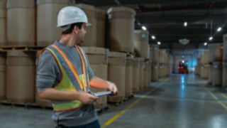 Den interaktiva varningsvästen från Linde Material Handling ger högre säkerhet En lagerarbetare bär den interaktiva varningsvästen från Linde Material Handling i ett mörkt lager