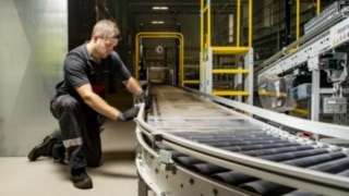 En servicetekniker från Linde MH reparerar en rullbana