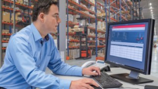 Truckflottsansvarig med fleet management-programvaran connect: Den truckflottsansvarige tittar på bildskärm med fleet management-programvaran connect: