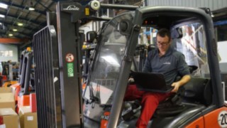 Tekniker som inspekterar en begagnad truck Tekniker som inspekterar en begagnad truck