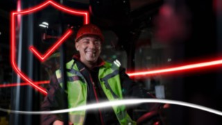Person i varselkläder och skyddshjälm sitter i en truck från Linde