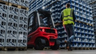 En fotgängare går bakom en truck som backar. En fotgängare går bakom en truck som backar.