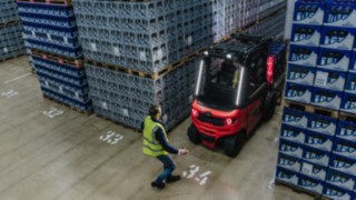 Linde Reverse Assist Radar minskar olycksrisken under backning. En elektrisk motviktstruck från Linde backar ut från en gång medan en fotgängare går förbi.