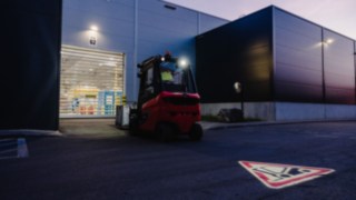 I skymningen närmar sig en truck en rullport på en industrihall. I skymningen närmar sig en truck en rullport på en industrihall.