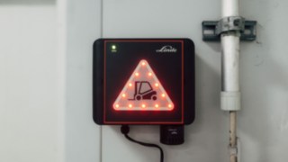 Ett avstånd på tio centimeter upprätthålls mellan trucken och port. Installerad Linde Door Control-enhet på port