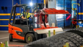 En anställd på Michelin Tyre PLC greppar en däckstapel med en däckklämma på Linde E20.