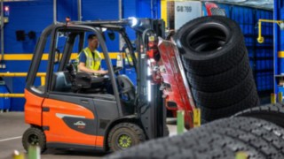 En anställd på Michelin Tyre PLC griper tag i en däckstapel med en klämma monterad på gaffeltrucken.