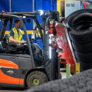 En anställd på Michelin Tyre PLC griper tag i en däckstapel med en klämma monterad på gaffeltrucken.