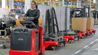 Logistiktåg från Linde i en hall Förare på logistiktåg från Linde i en hall