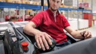 Tack vare armstödet sker alla styrrörelser utifrån handleden så att underarmen inte belastas i onödan. En medarbetare lägger handen på multifunktionsjoysticken från Linde Material Handling