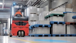 Framåt eller bakåt: Den ergonomiska hytten minimerar förarens fysiska belastning. En truckförare backar genom lagret med en eltruck från Linde.