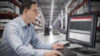 Omfattande anslutbarhet garanterar att truckarna enkelt kan integreras i befintlig infrastruktur och digitala processer. Person jobbar med dator