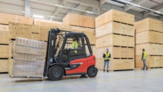 Fotgängare rör sig runt en motviktstruck utrustad med Linde Reverse Assist. Fotgängare rör sig runt en motviktstruck utrustad med Linde Reverse Assist.