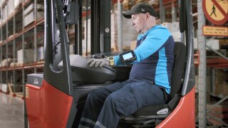 En truckförare hos PostNord kör en skjutstativtruck från Linde.