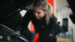 Servicetekniker Hanna mekar på en truck i en verkstad. Servicetekniker Hanna mekar på en truck i en verkstad.